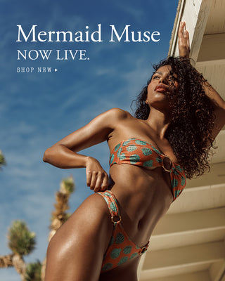 Woman in a colorful bikini standing against a blue sky with 'Mermaid Muse' text overlay.
